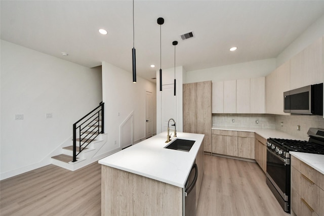 431 Neyland St, Houston, TX 77022 - kitchen featuring appliances with stainless steel finishes, modern cabinets, light brown cabinets, light wood-style floors, and backsplash