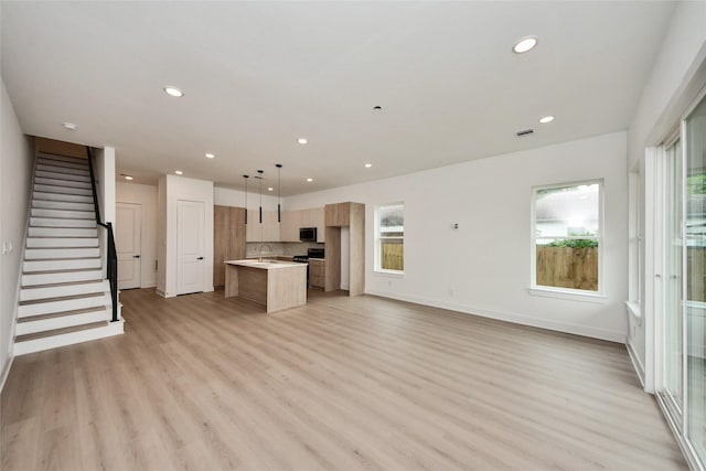431 Neyland St, Houston, TX 77022 - unfurnished living room featuring recessed lighting, light wood-style flooring, and stairs
