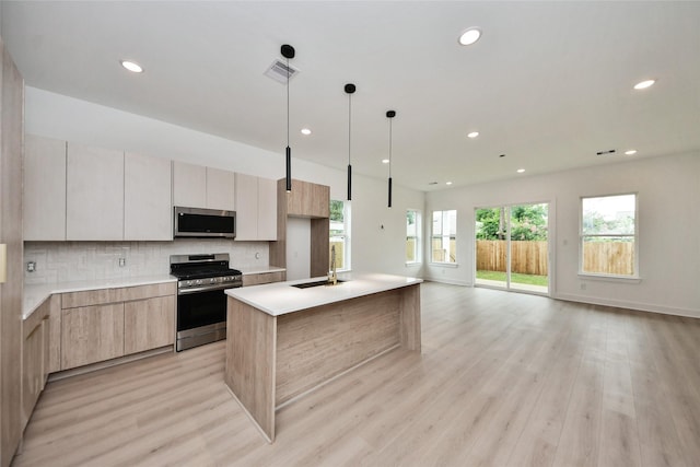431 Neyland St, Houston, TX 77022 - kitchen with stainless steel appliances, modern cabinets, light wood-type flooring, decorative backsplash, and recessed lighting