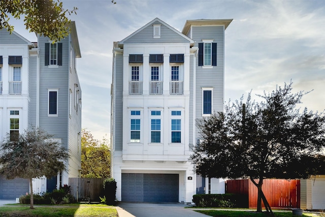 view of front facade with fence, an attached garage, and driveway
