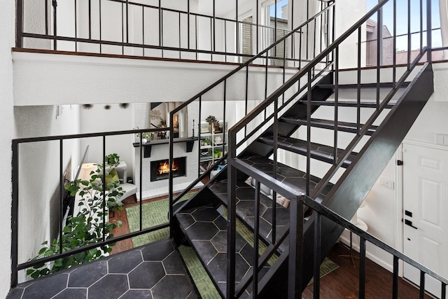 1115 Augusta Dr Unit 8, Houston, TX 77057 - staircase with a towering ceiling, healthy amount of natural light, and a lit fireplace
