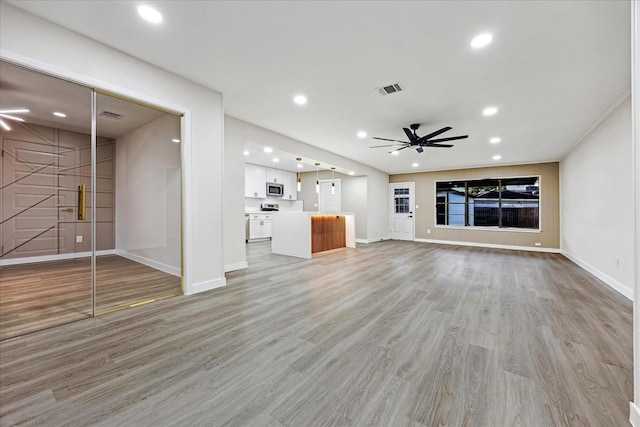 8902 Hendon Ln, Houston, TX 77036 - unfurnished living room with a ceiling fan, baseboards, light wood finished floors, and recessed lighting