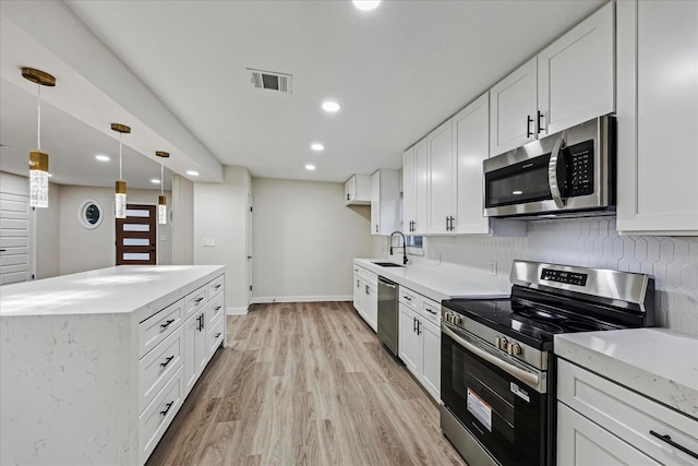 8902 Hendon Ln, Houston, TX 77036 - kitchen with stainless steel appliances, a sink, tasteful backsplash, light wood finished floors, and recessed lighting