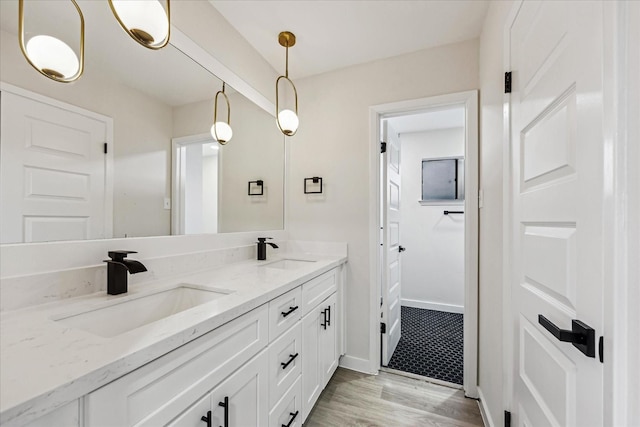 8902 Hendon Ln, Houston, TX 77036 - bathroom with wood finished floors, double vanity, and baseboards