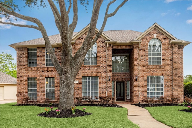 1703 Lakewinds Dr, Missouri City, TX 77459 - view of front of home with brick siding, a front lawn, and roof with shingles