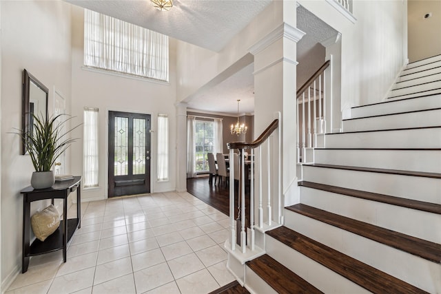 1703 Lakewinds Dr, Missouri City, TX 77459 - entryway featuring a chandelier, stairs, light tile patterned floors, baseboards, and a textured ceiling