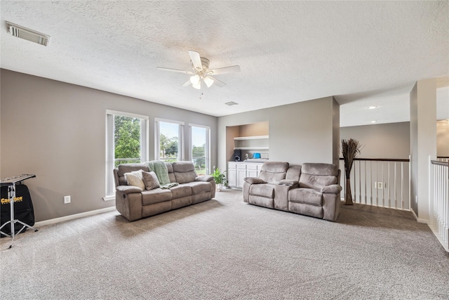 1703 Lakewinds Dr, Missouri City, TX 77459 - carpeted living room with ceiling fan, a textured ceiling, baseboards, and built in shelves