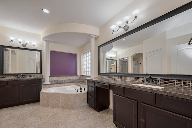 9968 Tallow Pointe Ln, Brookshire, TX 77423 - bathroom with decorative columns, a bath, backsplash, tile patterned flooring, and two vanities