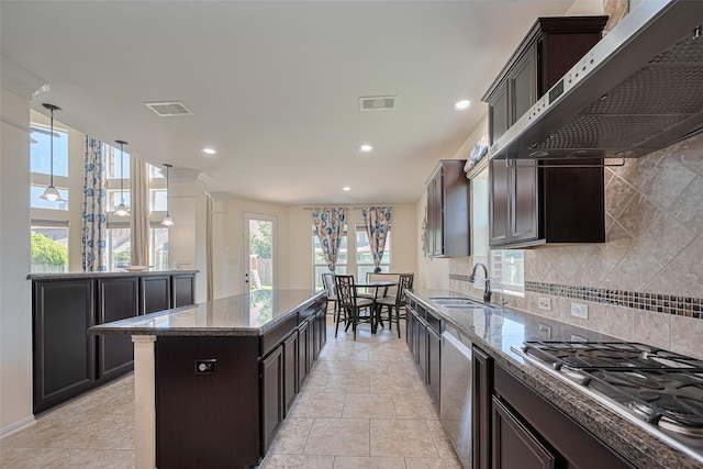 9968 Tallow Pointe Ln, Brookshire, TX 77423 - kitchen with a sink, appliances with stainless steel finishes, wall chimney range hood, stone countertops, and a center island