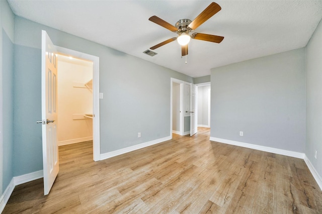 3726 Straightfork Dr, Houston, TX 77082 - unfurnished bedroom with light wood finished floors, baseboards, a walk in closet, and a ceiling fan