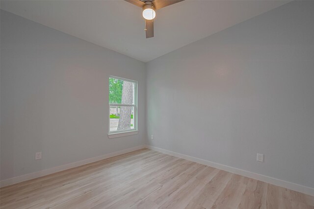 unfurnished room featuring light wood-type flooring, vaulted ceiling, baseboards, and ceiling fan