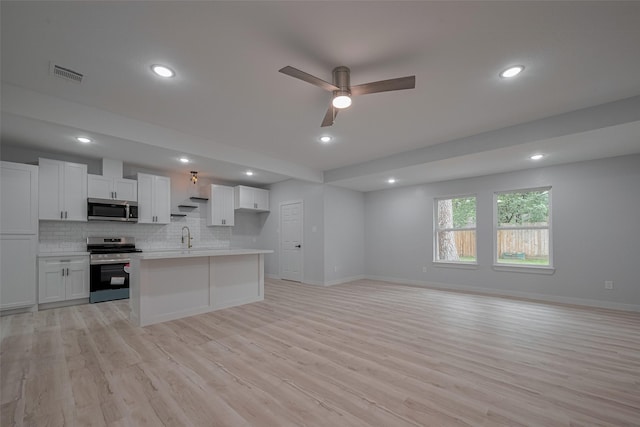 kitchen with stainless steel appliances, open floor plan, light wood-type flooring, a ceiling fan, and white cabinetry