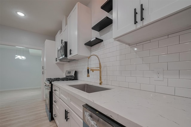 kitchen with appliances with stainless steel finishes, white cabinetry, backsplash, light stone counters, and recessed lighting