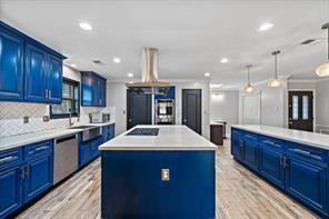 15418 Windy Cove Dr, Houston, TX 77095 - kitchen featuring blue cabinetry, dishwasher, a kitchen island, backsplash, and recessed lighting