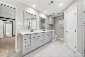 15418 Windy Cove Dr, Houston, TX 77095 - bathroom with baseboards, double vanity, toilet, and recessed lighting