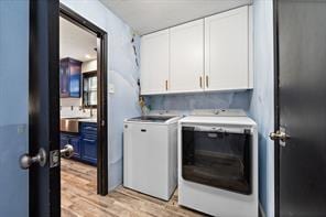 15418 Windy Cove Dr, Houston, TX 77095 - clothes washing area featuring cabinet space, washing machine and clothes dryer, and light wood-style floors
