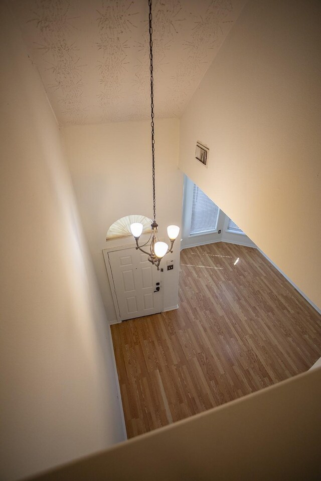 21926 Crestworth Ln, Katy, TX 77449 - stairs with wood finished floors, vaulted ceiling, a textured ceiling, and a chandelier
