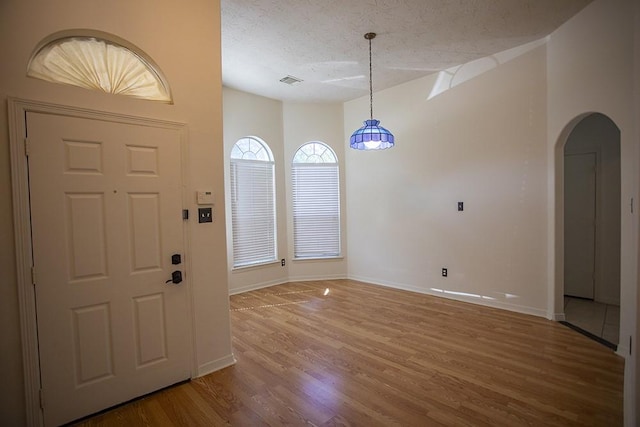 21926 Crestworth Ln, Katy, TX 77449 - foyer with wood finished floors, arched walkways, baseboards, and a textured ceiling