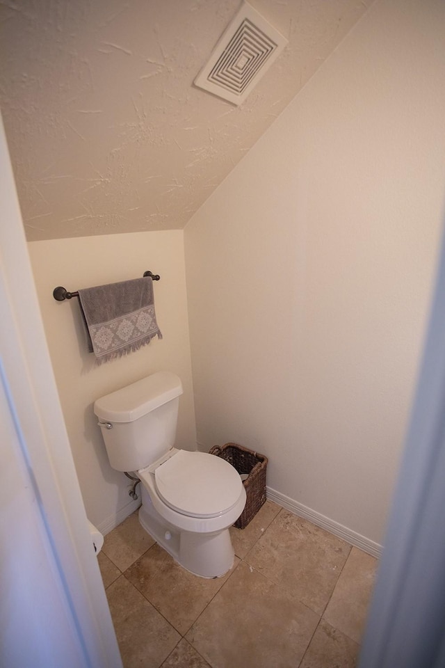 21926 Crestworth Ln, Katy, TX 77449 - bathroom with toilet, baseboards, lofted ceiling, tile patterned floors, and a textured ceiling
