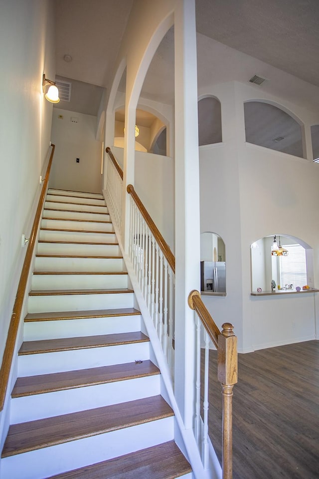 21926 Crestworth Ln, Katy, TX 77449 - stairway featuring wood finished floors, a towering ceiling, and a chandelier