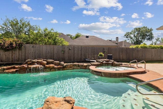 view of swimming pool featuring a fenced backyard and a pool with connected hot tub