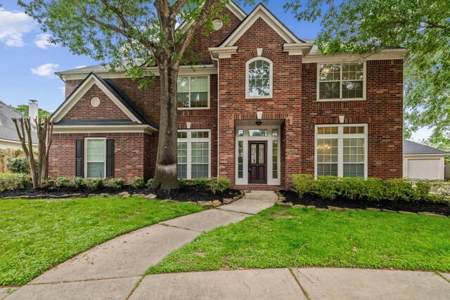 view of front of property featuring brick siding and a front lawn