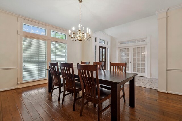 dining room featuring a chandelier, dark wood-style flooring, baseboards, french doors, and crown molding