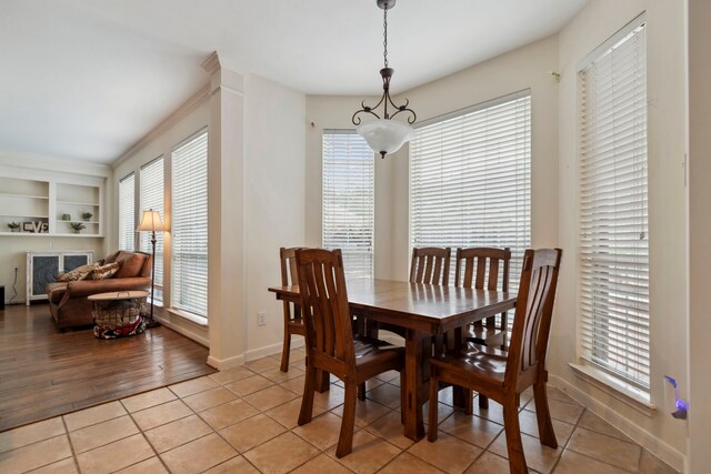 dining room with healthy amount of natural light, baseboards, light tile patterned floors, and built in features