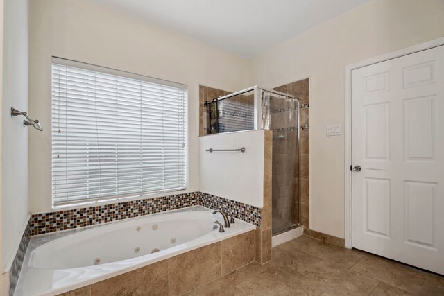 bathroom with a shower stall, a whirlpool tub, and tile patterned floors