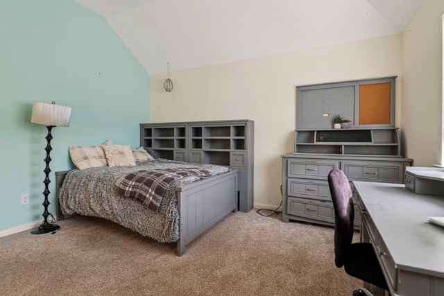 bedroom with vaulted ceiling, light colored carpet, a desk, and baseboards