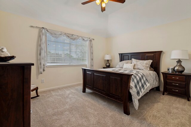 bedroom featuring light colored carpet, a ceiling fan, baseboards, and lofted ceiling