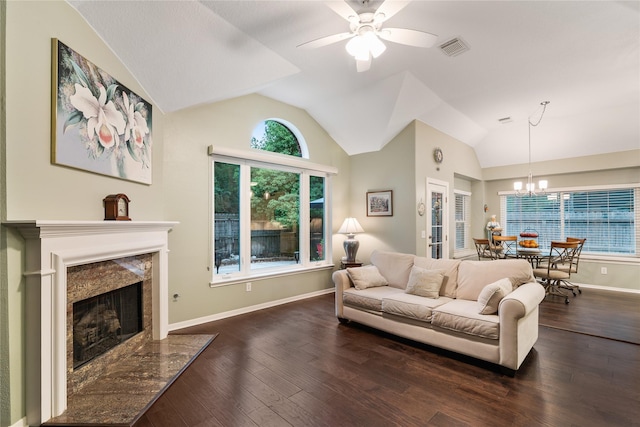 living area with vaulted ceiling, a fireplace, ceiling fan, a chandelier, and dark wood-type flooring