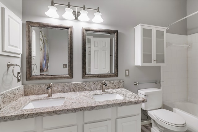 bathroom featuring toilet, double vanity, and tub / shower combination