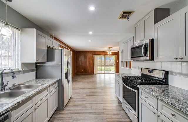 9502 Kell Cir, Houston, TX 77040 - kitchen featuring stainless steel appliances, a sink, light wood-style flooring, ceiling fan, and tasteful backsplash