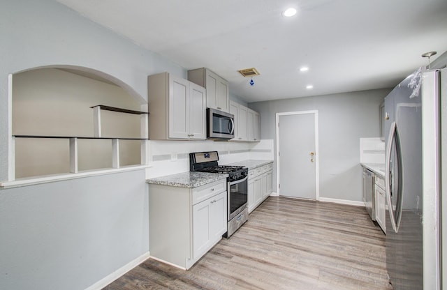9502 Kell Cir, Houston, TX 77040 - kitchen with stainless steel appliances, light wood-style flooring, baseboards, recessed lighting, and light stone counters