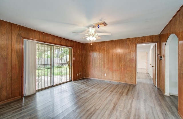 9502 Kell Cir, Houston, TX 77040 - empty room featuring wooden walls, arched walkways, a ceiling fan, wood finished floors, and baseboards