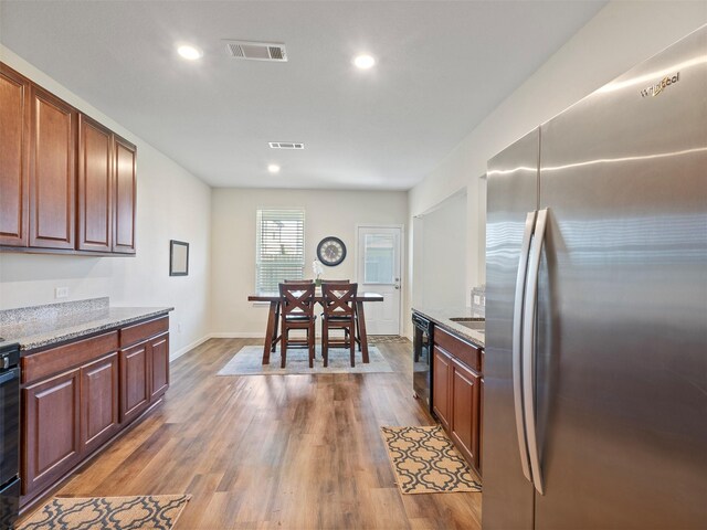 14506 Sweet Cherry Dr, Houston, TX 77069 - kitchen with freestanding refrigerator, dark wood finished floors, recessed lighting, light stone counters, and baseboards