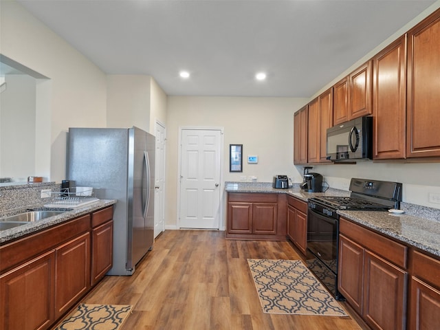 14506 Sweet Cherry Dr, Houston, TX 77069 - kitchen with black appliances, dark wood-style floors, stone counters, recessed lighting, and a sink