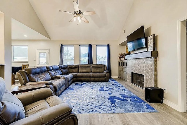 15538 Pine Valley Trl, Cypress, TX 77433 - living room featuring a brick fireplace, a ceiling fan, baseboards, wood finished floors, and high vaulted ceiling
