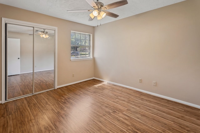 11802 Hamblin Rd, Cypress, TX 77429 - unfurnished bedroom featuring wood finished floors, baseboards, a closet, a textured ceiling, and a ceiling fan