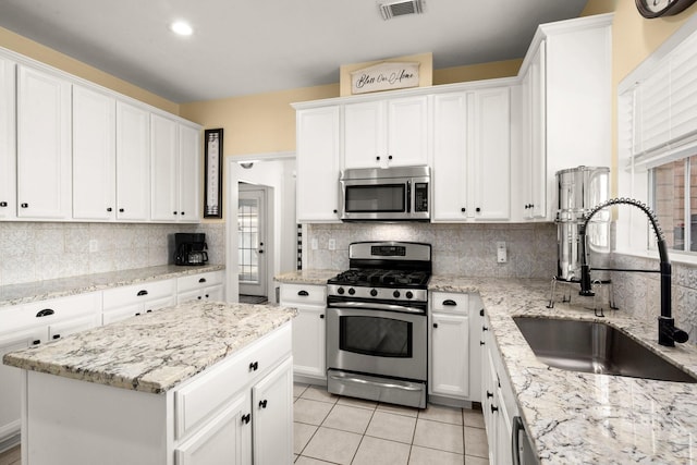 3233 Greenhead St, Katy, TX 77493 - kitchen with appliances with stainless steel finishes, a sink, backsplash, and white cabinetry