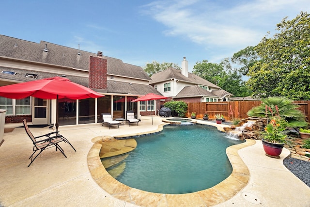view of pool featuring a fenced backyard, a patio, and a pool with connected hot tub
