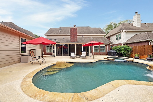 view of swimming pool featuring a patio area, fence, area for grilling, and a pool with connected hot tub