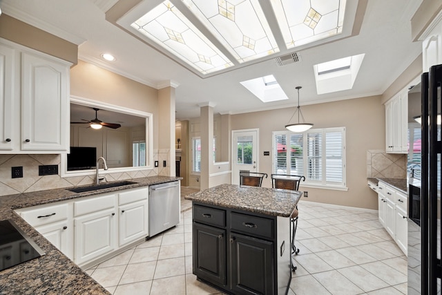 kitchen with dishwasher, a sink, white cabinets, a skylight, and crown molding