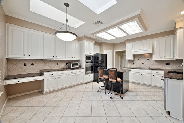 kitchen with a skylight, stainless steel appliances, tasteful backsplash, and crown molding