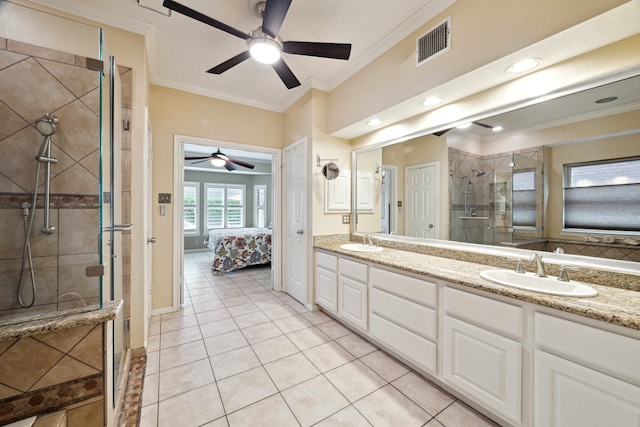 ensuite bathroom with ceiling fan, ornamental molding, a shower stall, double vanity, and tile patterned floors