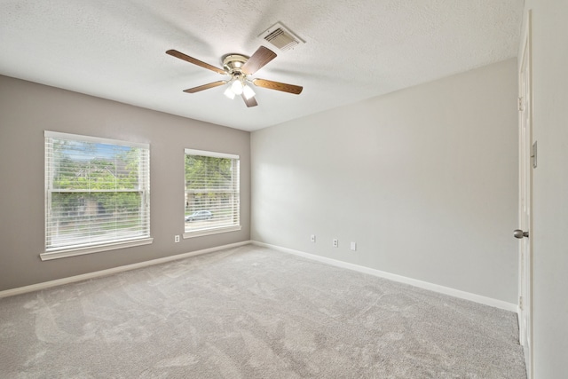 spare room featuring carpet, baseboards, ceiling fan, and a textured ceiling