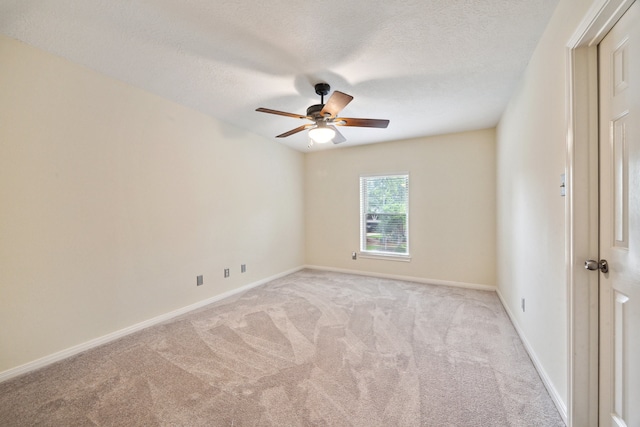 carpeted spare room featuring ceiling fan, baseboards, and a textured ceiling