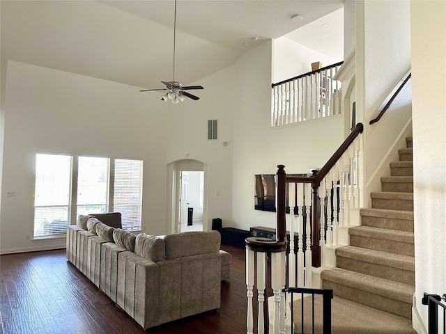 3522 Kent Knl, Missouri City, TX 77459 - living area with arched walkways, dark wood-style flooring, stairs, high vaulted ceiling, and ceiling fan