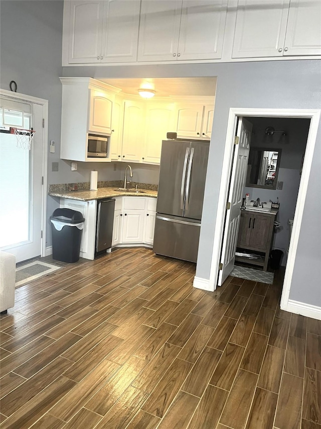 202 Golfview Dr, Normangee, TX 77871 - kitchen featuring stainless steel appliances, dark wood-style flooring, a sink, and baseboards
